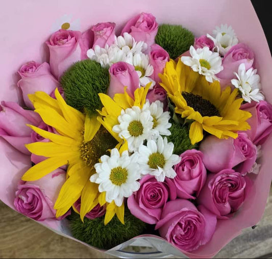VeryKenyan bouquet of pink roses, yellow sunflowers, and white daisies in a pink paper wrap.